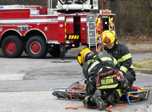 Firefighters attaching basket to rope.