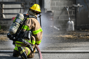 Firefighter operating firehose.